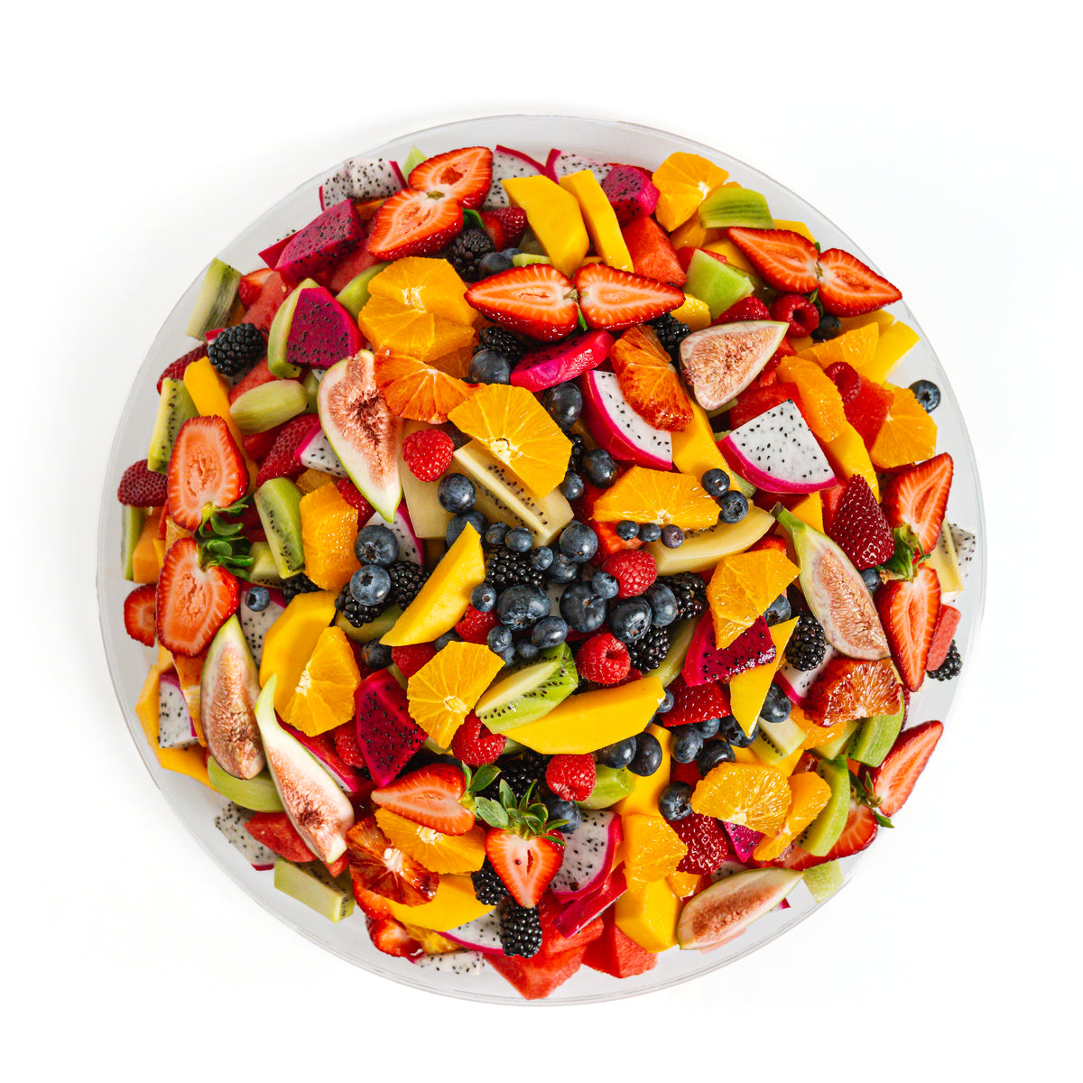Assorted fresh fruit salad arranged on a round platter, showcasing colorful fruits like melons, berries, and grapes.